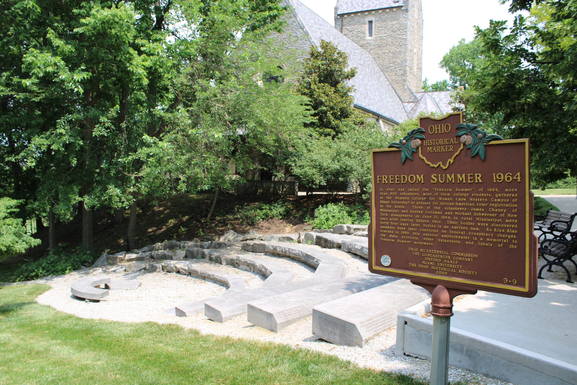 Stone seating in an outdoor amphitheater. A brown historical marker on the right reads "Freedom Summer 1964"
