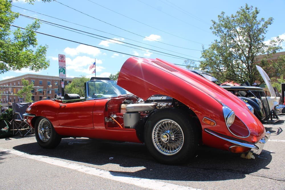 A red car sits on display at an Oxford car show