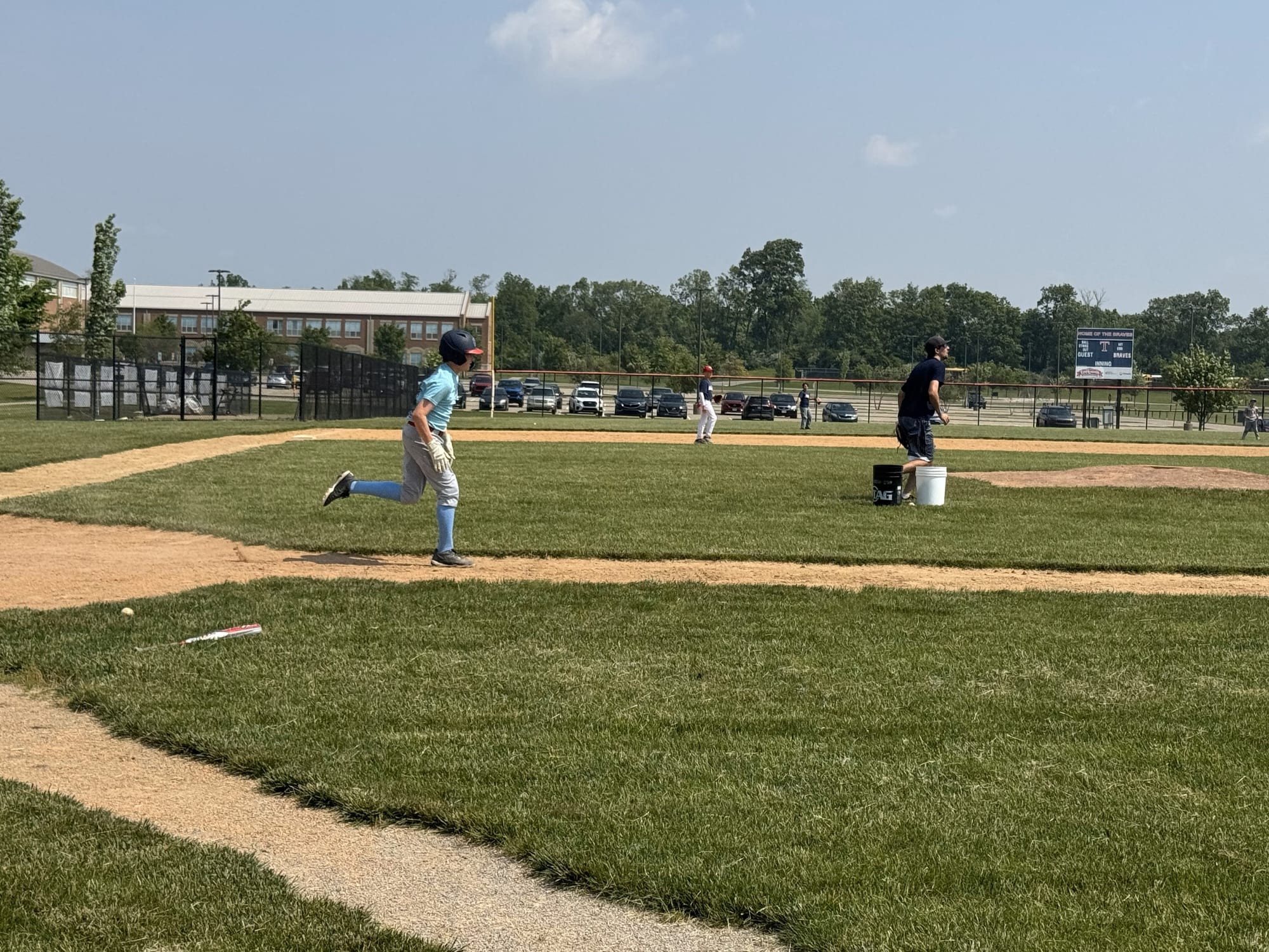 A middle schooler sprints towards first base during a scrimmage.