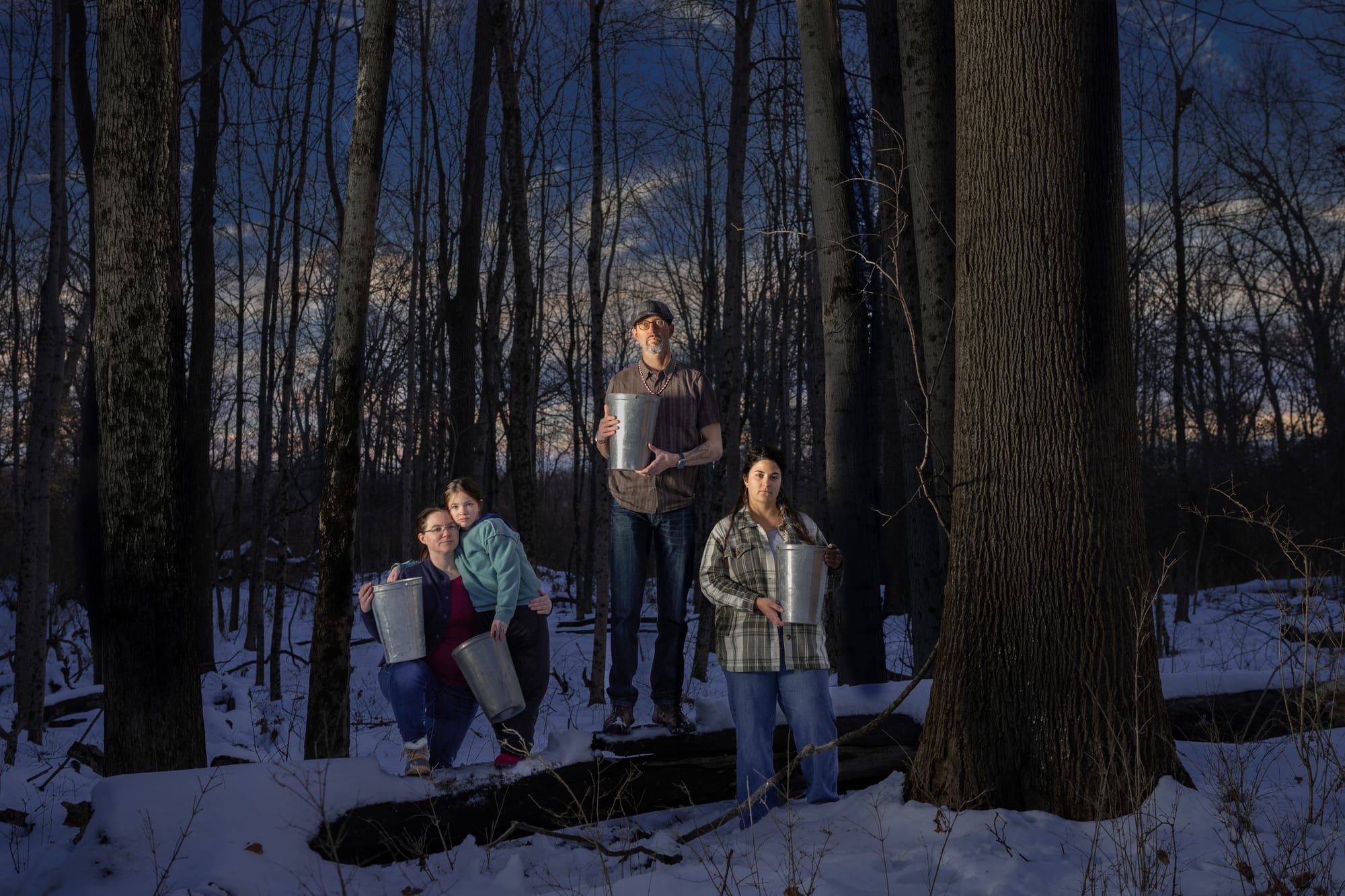 Kristina and Adeline Fox, George Ironstrack, and Kara Strass of the Miami Tribe of Oklahoma among Black Maples in Oxford, holding buckets used to gather sap from surrounding maple trees