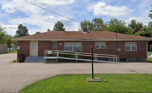 A small brick house with a wheelchair ramp