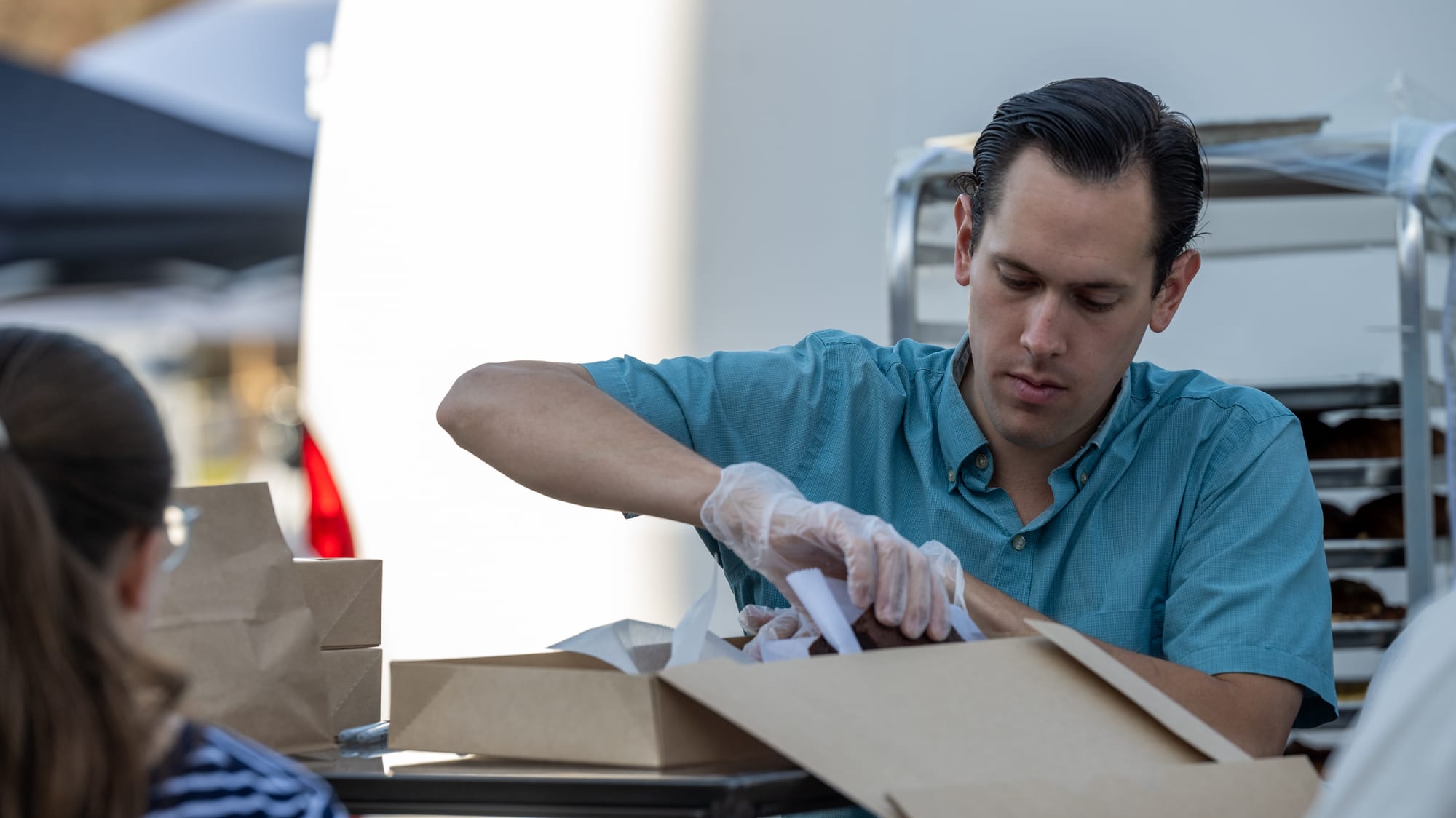 James Bigham, owner of Bigham Artisan Breads, packs a customer’s order at the Oxford Farmers Market