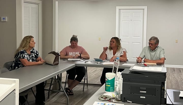 Ann McCoy, Danyell Bolser, Molly Cason and Michael Ruther sit at fold-out tables in a meeting room