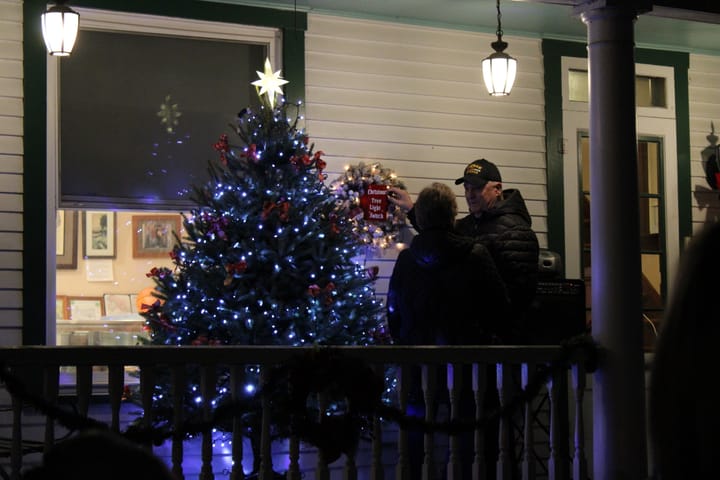Donald Shupp and his wife Kathy stand next to a Christmas tree on a porch