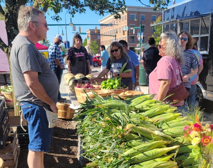 A booth at the Oxford Farmers Market sells sweet corn.