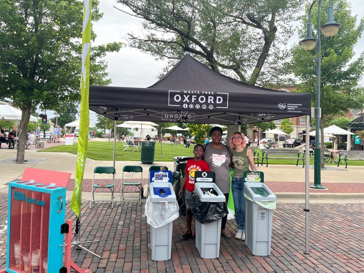 Kate Kozak and Oluwaseun Olubodun running a waste station in the Uptown park.