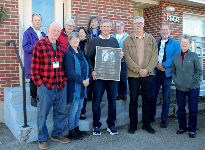Jeff Pulley, a significant financial contributor to the Oxford Winter House, poses with a commemorative plaque of his late mother, Martha Lee Pulley, next to the shelter.