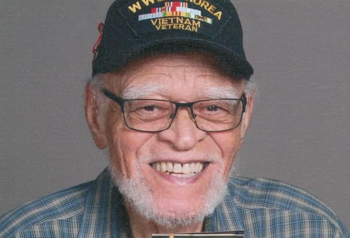Ennis Brewster Miller Sr., wearing a blue flannel and a black hat