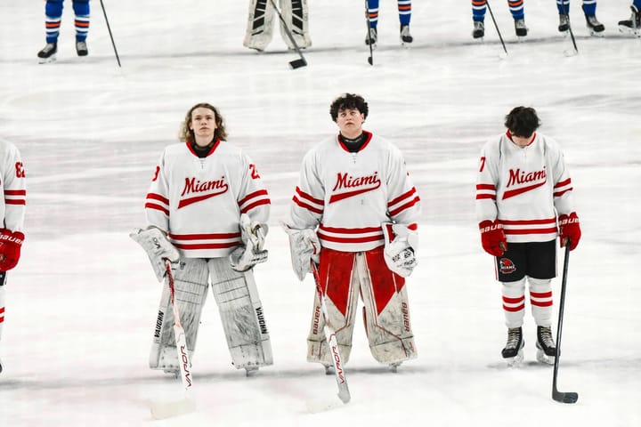 Andy Page (middle) at the Goggin Ice Center next to a fellow goaltender