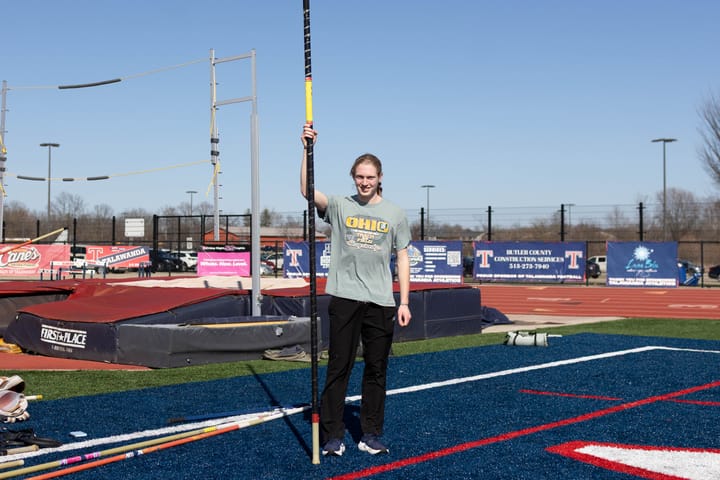 Nolan Hodgson stands next to the pole vault bag with his pole in hand